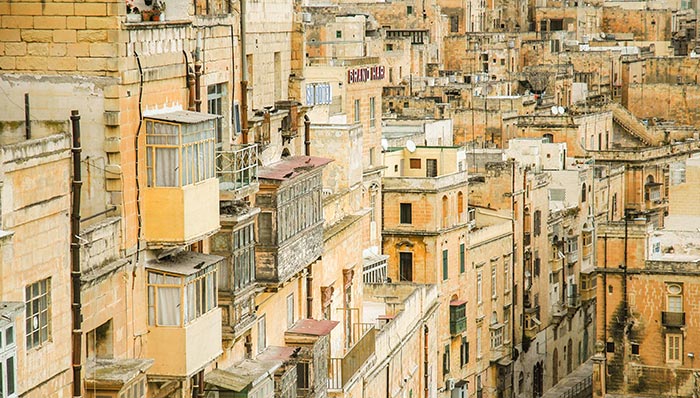 But first, to those who have only ever seen Malta as a sun-drenched, short-haul holiday destination, a brief history of the island. Malta is a small island, approximately 30 kilometres by 15 kilometres. In 1539, the Knights of St. John, a Catholic military and religious order dating back to the time of the Crusades, were granted sovereignty over Malta by the Holy Roman Emperor, Charles V. They ruled for 250 years, until 1798, when Napoleon Bonaparte's French forces invaded and seized control. Napoleon expelled the Knights, but only held the island for two years until the arrival of the British, who made it a protectorate and eventually a colony. In 1965, Malta gained its independence from the United Kingdom, becoming a sovereign state within the Commonwealth, and then transitioned from a monarchy to a republic, with a president as the head of state, ten years later. It joined the European Union, a major step in its integration with Europe, in 2004, adopting the Euro in 2008. Malta lies in the southern Mediterranean, at a point 100 km south of Sicily and 300 km north of the Libyan coast. Since the time of the Knights, it has been a strongly Catholic island with as many churches as there are days in the year. The Knights became famous for repelling the Ottomans in 1565, during the Great Siege of Malta, and were credited with being the frontline of the Christian defence of Sicily and ultimately Rome itself from Suleiman the Great’s Muslim invaders. However, Rome’s gratitude did not stop the Italians from joining with the Germans in bombarding the island during World War II. Malta was a vital strategic location, supplying the Allied forces in North Africa, as well as home to a significant naval base that defended the Suez Canal and the links to the Dominions in the east. It became the most bombed place on earth. It was on the point of surrendering to the Axis forces when the Germans became distracted by the opening of the Eastern Front and turned their attention to Russia. How different the outcome of the war could have been had the Germans not ruined their Russian allies. In recognition of this second Great Siege of Malta, George VI proclaimed: "To honour her brave people, I award the George Cross to the Island Fortress of Malta to bear witness to a heroism and devotion that will long be famous in history." `Despite its strong links to Europe and its admission into the European Union, Malta still retains a North African feel. The same traditional narrow streets with boxed, wooden Arabic balconies and flat-roofed limestone terraced housing can be found in Tripoli or Tunis. Newer, cheaper blocks of low-rise whitewashed housing crowd the so-called "villages" that form an urban sprawl on the east of the island, creating some of the densest population concentrations in Europe. Even the Maltese language reinforces the island's links with Africa and the Middle East. Its rough, guttural Semitic tongue originates from the Phoenician settlers, from what is now Lebanon, who settled the island some 800 years before the Common Age. The official language of the Knights was Italian, but the Maltese dialects survived dialects and, uniquely for an Arabic tongue, were written using the Latin alphabet. In the years following independence, Malta developed a ‘Look Southwards’ policy, centred around forging links with Gaddafi’s Libya. Before its civil war, Libya had a thriving oil industry and used its reserves of currency to expand its influence across Africa and beyond. This shift was largely driven by economic necessity. Malta needed to replace the revenue and jobs lost with the gradual withdrawal of the British military, which culminated in the closure of its naval base in 1979. Malta received millions in aid and loans from Libya, and a strong relationship has existed between the two countries since that time. It is worth noting that there is extensive documentation, including court judgments and investigative journalism, pointing to the fact that significant funds of questionable origin linked to the Gaddafi family were held in Maltese banks and company accounts around the time of his death in 2011. In the Inspector George Zammit books, I explore the darker present-day links between Libya and Malta, including money laundering, oil smuggling, sanction busting, the civil war, and migrant trafficking. As Inspector George Zammit discovers in his adventures, such activities are not confined to Malta and Libya, but are prevalent throughout the Southern Mediterranean basin. Apart from the long-term implications of the ‘Look Southwards’ policy, Malta is also a close neighbour to Sicily and southern Italy. A recent Europol report ranked Malta among the top five countries targeted by organised crime networks. Italian, Russian and various Eastern European crime groups are all involved in extortion, money laundering, fuel smuggling, people trafficking, and drug trafficking operations. (See my later article about the impact on Hurds Bank, the offshore shallows, where illicit ship-to-ship transfers facilitate much of this international crime.) Although Malta already had a dubious reputation as being a shady financial centre, the murder of an investigative journalist profoundly impacted the island (and the rest of Europe), exposing deep-seated issues within the country’s political and business landscape. Along with weak governance, poor policing, and a tardy judiciary, Malta also suffers from what I call small island syndrome. In a population of some 550,000 where the island's size limits individual mobility, everybody knows everybody else. The 100 most popular surnames are shared by roughly 75% of the population. Families are large and interconnected, and politics is a fierce, partisan affair, where both main parties commonly buy influence in their pursuit of power. It is the same in the south of Italy and Sicily, where governance is weak and communities compensate by developing their own loyalties and codes of ethics, even if that includes criminal behaviours. Following independence, there were periods of serious poverty, leading to large-scale migration across the Commonwealth, and a loss of confidence in the state's ability to provide the most basic support. For those that remained, families had to do what they could to survive and this provided the background for the formation of a ‘family first’ mentality, which still exists to this day. There is a culture of self-interest and impunity on the island that stretches from the very top of government down to the community level. The sustained economic growth since joining the EU (average GDP growth of 5.5% per annum) has also led to a 'get-rich-quick' culture, where entrepreneurship often outstrips regulation and good governance and looking after number one is the most objective. An independent inquiry, by three retired Maltese judges in 2021, into the death of the journalist concluded that the Maltese state bore responsibility for creating a "climate of impunity" that enabled the killing of the journalist. This included findings of online harassment campaigns against her by staff serving those in high office. The inquiry also attributed indirect responsibility to high-ranking officials for failing to act against their associates whose secret companies were exposed in public disclosures, namely the Panama Papers. The state's acknowledged contribution to a "climate of impunity" is evidence of the broader systemic failures in governance and accountability I have already mentioned. To give you an idea of the climate at the time of the murder, it is worth understanding the political scene. The Maltese Labour Party won power in 2013, after 15 years in opposition, under the leadership of Joseph Muscat. Muscat was a young, energetic MEP and former journalist who understood the meaning of power and was unafraid to use it. His first few months were spent systematically purging the Maltese civil service, firing every permanent secretary and replacing them with Labour Party apparatchiks – so-called ‘persons of trust’. Every Labour MP, not already in the cabinet, was placed on the state payroll. Politically certain associated members of the armed forces jumped four ranks, and senior policemen were similarly replaced by party loyalists. Malta’s lust for construction and development was further facilitated by the removal of the planning chiefs and the appointment of developer-friendly party members. The heads of regulatory bodies were removed, and inexperienced but loyal ‘yes men’ took their place. The former BBC journalist and co-author of the book Murder on the Malta Express, John Sweeney, describes Muscat’s Labour Party not as a political party, but as a cult, intent on plundering the public purse. Muscat effectively captured the state apparatus and proceeded to bend it to his will. For those who are unfamiliar with the journalist I am referring to, let me explain who she was and why her significance extends far beyond this small island in the southern Mediterranean. She wrote a blog, widely read in Malta and abroad, called Running Commentary, which ruthlessly exposed allegations of corruption among senior Maltese politicians from all parties and those ‘bigwigs’ in the local business community. At the time of her death, she was contesting over forty libel cases, many brought by government officials who had been offended by the spotlight she had shone into the darker corners of their activities. The blizzard of lawsuits was designed to drain her of time, energy and money, blatantly attempting to silence her investigative reporting on corruption and organised crime. They had a pivotal effect, and in 2024, the EU responded to this abuse of process by issuing a directive requiring all EU states to protect those finding themselves defending "manifestly unfounded claims or abusive court proceedings", so-called ‘SLAPP’ actions. To this day, these recommendations to protect journalists and others have still not been fully implemented in Malta. More immediate threats to the journalist in question came in the form of her house being firebombed, the slaughter of a pet dog and messages containing threats to kill. The government’s response was to withdraw the police protection she had previously enjoyed. Unfortunately, these threats were to prove all too real. The massive car bomb that killed her was triggered by a mobile phone call from a small fishing boat cruising in Malta’s Grand Harbour, acting on a prompt from an observation post on a hilltop some distance from her home. Investigators from the Netherlands, Europol and even the FBI, helped the Maltese Pulizija piece together the events leading up to the October 2017 murder, gathering forensic evidence and data from mobile phone calls. In December of that year, three men ‘known to the police’, Vincent Muscat (no relation to the Prime Minister) and two brothers, Alfred and George Degiorgio, were arrested at their premises in the ‘potato sheds’ area of Valletta’s docks. They had been forewarned that the Pulizija were on their way and threw their mobile phones into the Grand Harbour, from which police divers later retrieved them. For the Maltese authorities, there was a feeling of ‘mission accomplished’, as the carefully collected forensic and mobile phone evidence presented a damming case against the three of them. However, it took three years of delays, interim applications and time wasting before Vincent Muscat made a plea deal, spilt the beans and received a 15-year sentence. His two co-defendants, the brothers, who were accused of detonating the bomb, served a further eighteen months on remand before pleading guilty to all charges in 2022 and receiving sentences of 40 years in prison. They had made more than 100 preliminary pleas to the court. These included numerous requests for pardons in exchange for information about the involvement of Maltese politicians in this and other murders, but eventually, when all else failed, they changed their plea to guilty. The main question, though, is why the journalist was murdered and by whom? Unfortunately, despite the evidence produced to date and the many theories in circulation, it is not going to be possible to discuss these questions due to the imposition of controversial ‘blackout orders’, made in the trial of the individual accused of being the mastermind behind the murder of the journalist. The "blackout orders" refer to a series of judicial directives culminating in the most comprehensive decree that prevents me from writing or discussing any information about the case of the murdered journalist or the accused individual. This sweeping prohibition extends to all forms of media coverage, public discussions and debates related to the case. There is an exception for the publication of full, verbatim transcripts of court proceedings, implying that any analysis, commentary, or reporting beyond the direct court proceeding is forbidden. This situation has ignited a fierce debate over press freedom and the public's right to information. I am not a journalist, and certainly not an investigative journalist. In Malta, it takes a particular form of courage to follow that specific occupation. However, in my series of six Inspector George Zammit books, set in Malta, I assume the existence of corruption in high places and consider the inefficiencies within the Maltese judicial system as a given. For more background on the case, in material already published before the ‘blackout’, I recommend Murder on the Malta Express: Who Killed Daphne Caruana Galizia? written by three journalists: John Sweeney, Manuel Delia, and Carlo Bonini and A Sunny Island for Shady People written by Ryan Murdock. Manuel Delia, along with John Sweeney, are the host of the podcast Crooks Everywhere, which further explores the journalist’s assassination and the theme of corruption in Malta. In a small island where speculation and rumour is rife and where leaks from within the justice system are commonplace, it is understandable why the courts have taken steps to prevent prejudice to the accused's right to a fair trial. However, the extent of the orders is disproportionate and undermines the public’s right to know. Their unlimited duration, in a country where it can take many years to bring a case to trial, is also considered excessive and detrimental to public trust. Were the bans limited to information that would be directly prejudicial to the proceedings themselves, they would be more reasonable in scope. But as drawn, they are so wide as to stifle journalistic investigations into the many outstanding questions that still surround the case, which is particularly difficult to justify in a system tarnished by allegations of corruption and political misconduct. The orders give judicial support to an environment of secrecy and lack of transparency that only further erodes the public's trust in the apparatus of the state. I suspect it will be several years before the current proceedings, which led to the bans, reach a trial. In that time, all discussions or publication of materials about the case will remain subject to the court's orders. In a small island of less than half a million people, where everything and everyone is in some way interconnected, it seems a breach of a fundamental human right that the citizens are unable to discuss, or remain informed of developments in a case that goes right to the very heart of government and concerns the relationship between the state and the individual. The inspiration for Inspector George Zammit came from this stark environment of secrecy, lack of transparency, and deep-seated corruption—a world where impunity reigns. George is no hero or crusader; he is an ordinary family man, a policeman simply trying to do his job. Yet, he is always thrust into adventures not of his own making, forced to confront powerful forces determined to bend and shape him. In his world, the moral compass is broken: good people do bad things, and bad people do good things. Inspector George Zammit constantly finds himself in a moral quandary, yearning for a quiet life while the turbulent tides of Maltese society drag him into dilemmas with no easy answers. In the meantime, get your guidebooks, pack a hat and sunscreen and enjoy the best of Old street in Valletta Malta